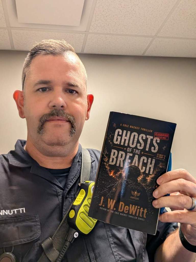 Reader holding a copy of Ghosts of the Breach
