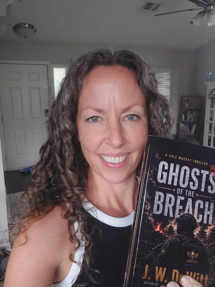 Reader smiling while holding Ghosts of the Breach